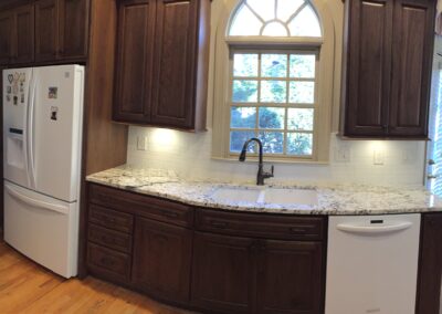 A modern kitchen featuring a sleek sink and a spacious refrigerator, showcasing a clean and organized space.